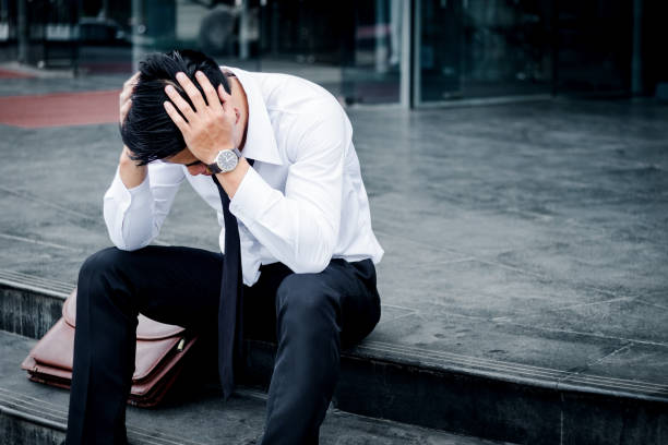 istock Unemployed Tired or stressed businessman sitting on the walkway after work Stressed businessman concept 831518232