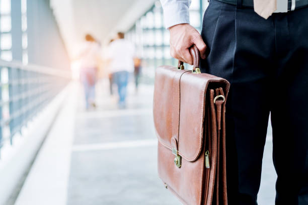 empresario sosteniendo un maletín los viajeros caminando al aire libre - men briefcase business bag fotografías e imágenes de stock