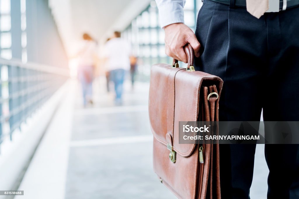 Businessman holding a briefcase travellers walking outdoors Arrival Stock Photo