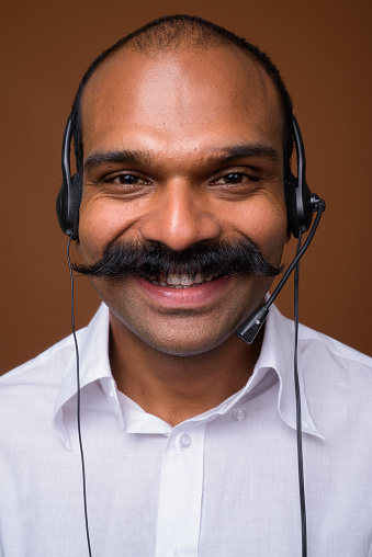 Studio Shot Of Indian Man Call Center Representative Wearing Headset  Against Colored Background Stock Photo - Download Image Now - iStock