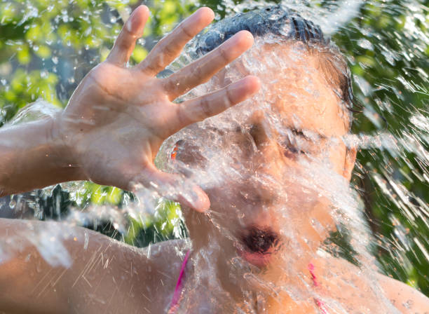 istock Water splashes fall on a young girl 831529920