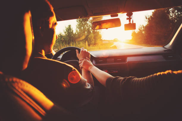 istock Couple driving car on way to sunset 831536420
