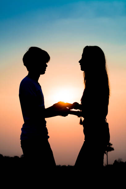istock silhouette romantic couple on sunset. 831543510