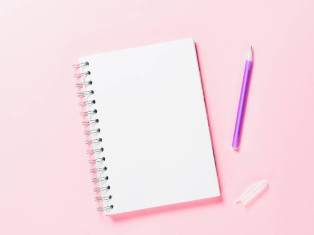 istock Top view of blank note with pen on pink background 831544332