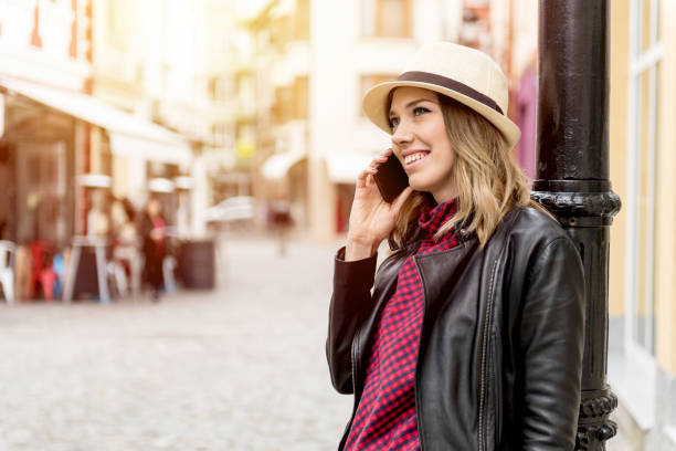 istock Young woman using phone outdoors 831547690
