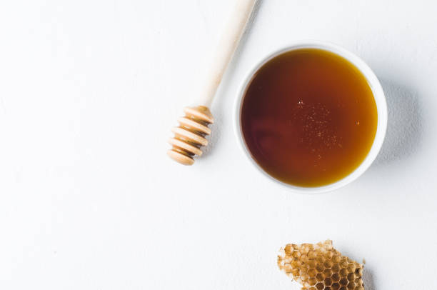 istock Fresh honey in a white cup on a white concrete background 831548266