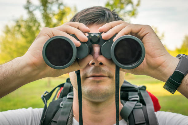 istock Traveler man looks through a binoculars 831558654