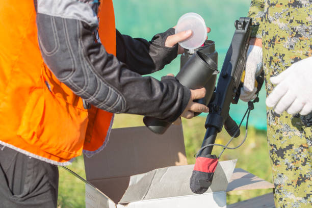 two persons loading paintball gun with balls outdoors. - paintballing violence exercising sport imagens e fotografias de stock