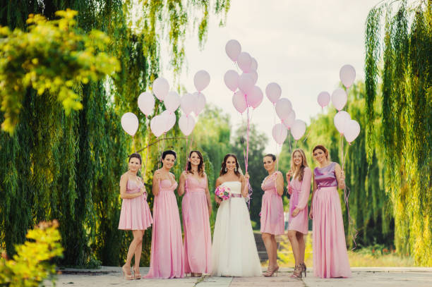 istock Bride with bridesmaids in pink dresses for a walk 831559418
