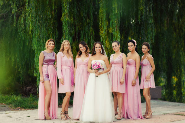 istock Bride with bridesmaids in pink dresses for a walk 831559456