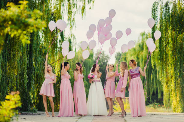 braut mit brautjungfern in rosa kleider für einen spaziergang - women bride personal accessory adult stock-fotos und bilder