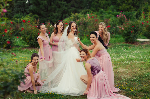 istock Bride with bridesmaids in pink dresses for a walk 831559480