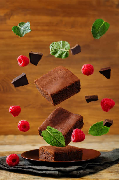 istock Flying Chocolate cake Brownie with mint and raspberries 831559518