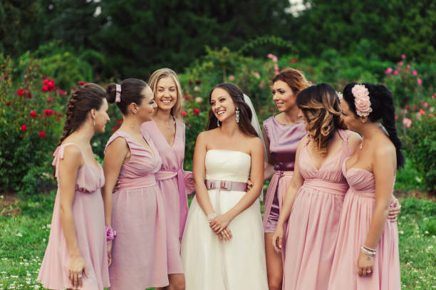 istock Bride with bridesmaids in pink dresses for a walk 831559562