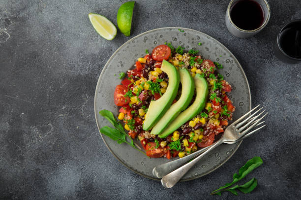 istock Avocado, quinoa, bean, corn and bell pepper salad, grey background 831559592