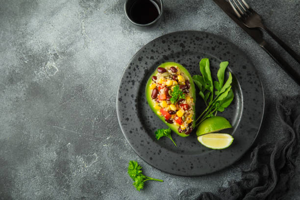 Avocado,quinoa,  black  bean, corn and bell pepper salad served in avocado