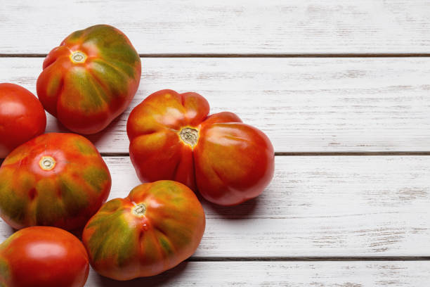 istock Tomatoes of unusual shape on white plates. 831563968