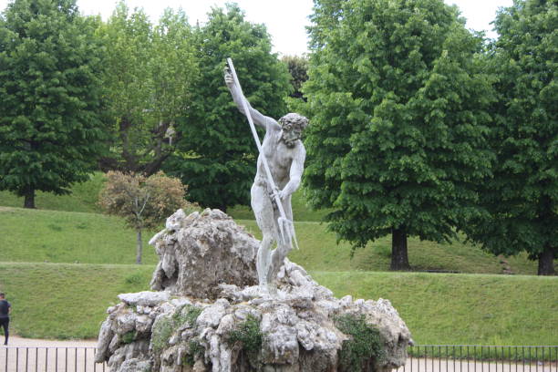 Florence, Italy: May 3, 2017 - Image of Boboli Gardens in Florence. This is most famous urban park. Boboli’s most famous spouting fountain—Stoldo Lorenzi’s bronze of Neptune clutching his three-pronged trident. The fountain was created in 1565 by sculptor Stoldo Lorenzi for Duke Cosimo I de’ Medici, and a nursery once surrounded it. In the eighteenth century, the nearby area was renovated with the creation of the Basin of Neptune, which had to collect the irrigation water around the garden.