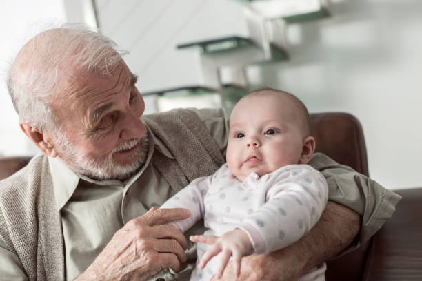 Grandfather and granddaughter in living room Grandfather and granddaughter in living room at home old man baby stock pictures, royalty-free photos & images