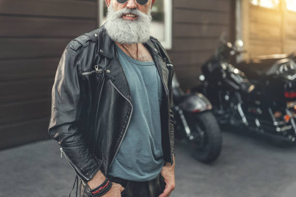istock Cheerful smiling aged man near motorbikes 831581436