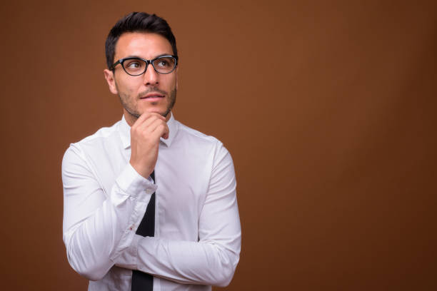 istock Studio shot of young handsome Hispanic businessman against colored background 831581680