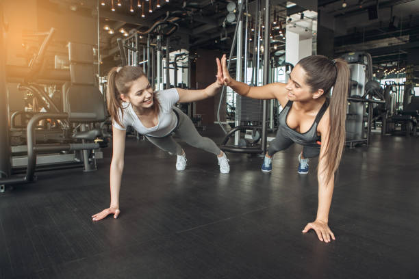 istock Young women exercise together in the gym 831582058