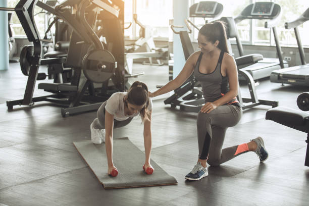 istock Young women exercise together in the gym 831582204