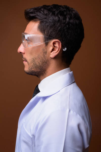 istock Studio shot of young handsome Hispanic man doctor against colored background 831584574