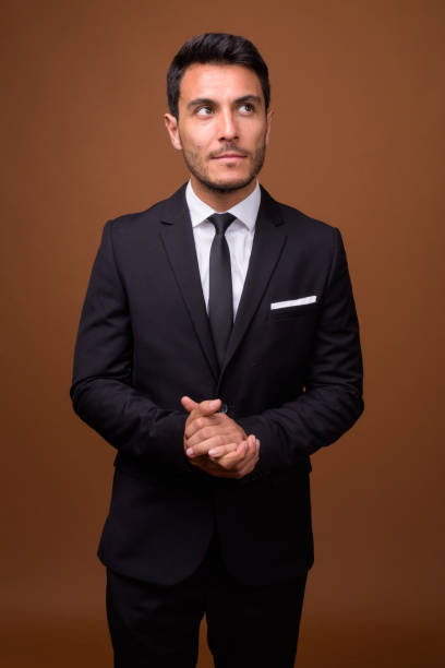 istock Studio shot of young handsome Hispanic businessman against colored background 831584604