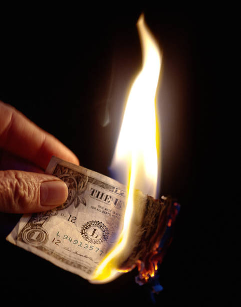 istock Hand holding burning American One Dollar banknote 831585678