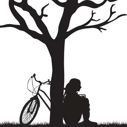 Woman and bicycle leaning against a tree