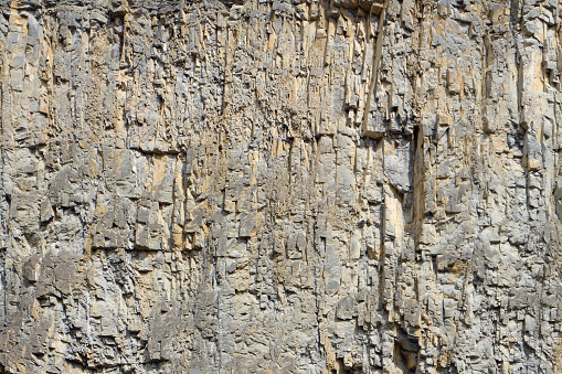 A large stone wall at a quarry. The surface is the result of controlled explosions to gain loose rocks for construction works and other purposes.