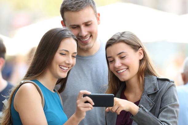 istock Friends sharing media content on the srteet 831589424