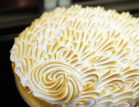 Cropped look at a tempting lemon meringue pie on display.