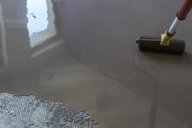 istock Floor covering with self leveling plaster. Mirror smooth surface of the floor. Roller application 831590470