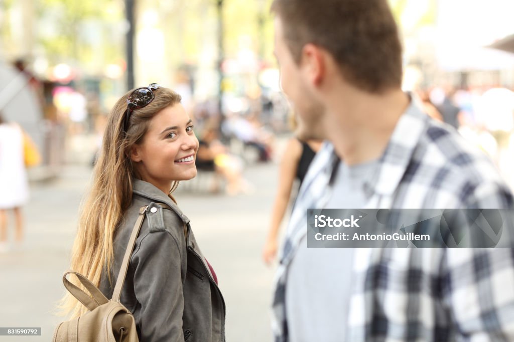 Strangers girl and guy flirting on the street Strangers girl and guy flirting looking each other on the street Love At First Sight Stock Photo