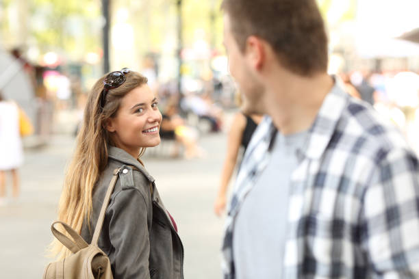 Strangers girl and guy flirting on the street Strangers girl and guy flirting looking each other on the street charming stock pictures, royalty-free photos & images