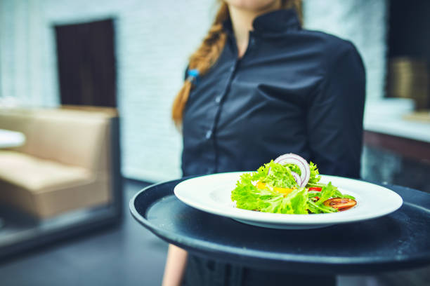 istock Waiters carrying plates with food, in a restaurant. 831591388