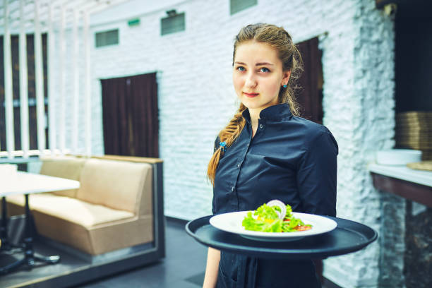istock Waiters carrying plates with food, in a restaurant. 831591396