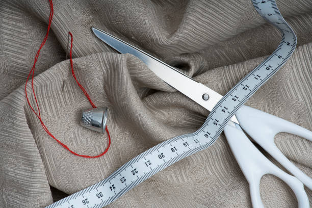 Scissors with measuring tape and thimble Scissors with measuring tape and thimble on a beige blanket needles eye stock pictures, royalty-free photos & images