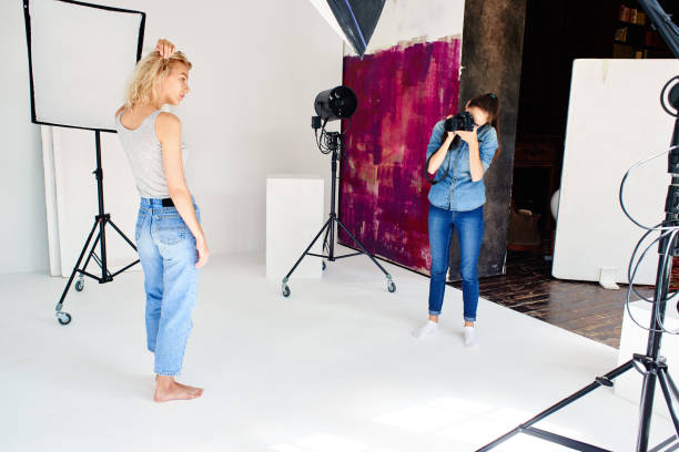 istock Girl photographer works in Studio with a model 831597446