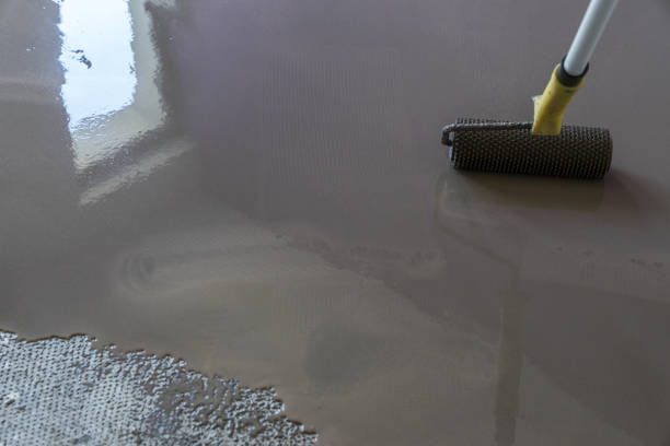 istock Interior of house under construction. Floor covering with self leveling cement mortar. Mirror smooth surface of the floor. Roller application 831597468