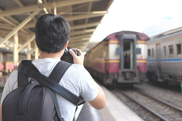 istock Back view of photographer taking a picture in train station. Selective focus and shallow depth of field. 831601310