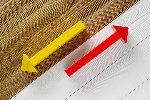 Two arrows pointing in opposite directions. Two wooden arrows red and yellow.