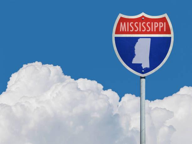 istock Highway sign for Interstate road in Mississippi with map in front of clouds 831610792