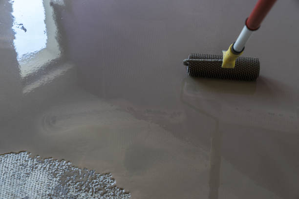 istock Mirror smooth surface of the floor. Floor covering with self leveling cement mortar. Roller application 831610914