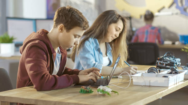 istock Smart Young Boy Works on a Laptop For His New Project in His Computer Science Class. 831613752