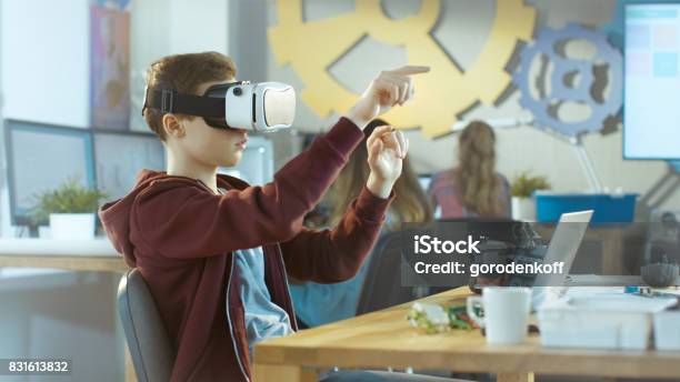 In A Computer Science Class Boy Wearing Virtual Reality Headset Works On A Programing Project Stock Photo - Download Image Now