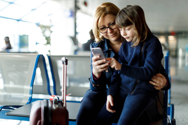 istock Mother and child using smart phone at airport 831614626