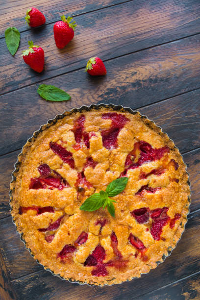 istock Shortcake with strawberry in a black baking pan on the wooden rustic table, top view. 831617222